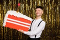 Photo of excited dreamy young man wear white shirt ready blow birthday cake candle isolated golden glitter background