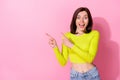 Photo of excited funky lady wear yellow top looking pointing two fingers empty space open mouth isolated pink color