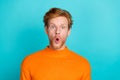 Photo of excited funky young man wear orange pullover big eyes isolated teal color background