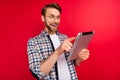 Photo of excited funny young guy wear checkered shirt glasses typing modern device big eyes isolated red color Royalty Free Stock Photo