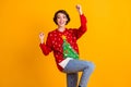 Photo of excited girl in christmas tree decor pullover sweater denim jeans raise fists x-mas newyear lottery win Royalty Free Stock Photo