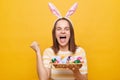 Photo of excited happy satisfied woman wearing rabbit ears holding colorful Easter eggs found the greatest number of eggs in the Royalty Free Stock Photo
