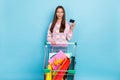 Photo of excited lady hold big x-mas gift trolley show debit card wear pullover blue color background
