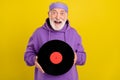 Photo of excited man pensioner good mood hold vintage vinyl disc isolated over yellow color background