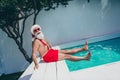 Photo of excited pretty santa claus wear red shorts smiling ready swimming celebrating new year outdoors villa spa-hotel