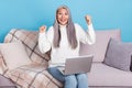 Photo of excited senior woman rejoice victory fists hands sit divan use laptop discount over blue color