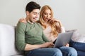 Excited surprised young loving couple using laptop computer.