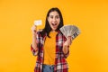 Photo of excited woman smiling while holding credit card and dollars Royalty Free Stock Photo