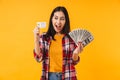 Photo of excited woman smiling while holding credit card and dollars Royalty Free Stock Photo