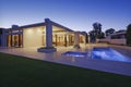 Exterior of modern home with swimming pool at dusk