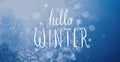 Photo of falling snow in sunny day with Hello Winter lettering.