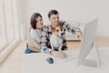 Photo of family couple make shopping on favourite website, enjoy time together, funny dog focused in monitor of computer, sits in Royalty Free Stock Photo