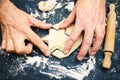 A photo of father`s hands cutting the star with a cookie cutter on the wooden table. An overhead photo of man`s hands, flour, wh Royalty Free Stock Photo