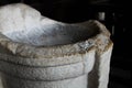 White marble bowl inside Rome Colosseum, Italy, against a dark background