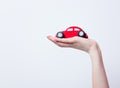 Photo of female hand holding car shaped toy on the wonderful whi Royalty Free Stock Photo