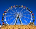 Ferris wheel with colorful swings at sunsets with blue sky in front view