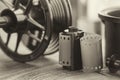 Photo film roll and cassette, photographic equipment - developing tank with its film reels on background. Selective focus.