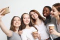 Photo of five multiethnic girls laughing and taking selfie