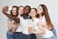 Photo of five multiethnic girls laughing and taking selfie