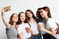 Photo of five multiethnic girls laughing and taking selfie