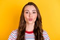 Photo of flirty adorable young lady dressed striped t-shirt sending you kiss isolated yellow color background