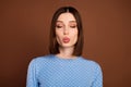 Photo of flirty bob hairdo young lady blow kiss wear blue blouse isolated on brown color background