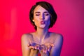 Photo of flirty brunette hairdo young lady blow kiss without clothes isolated on vibrant neon red color background