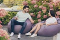 Photo of flirty romantic couple guy lady sit beanbag have conversation wear casual clothes park outside Royalty Free Stock Photo