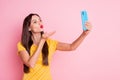 Photo of flirty young woman send air kiss hand phone take selfie wear yellow dotted t-shirt on pink color