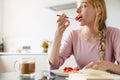 Photo of focused beautiful woman reading book while having breakfast