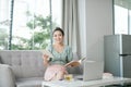 Photo of focused business woman hold pen sit sofa write notes fingers specs in home workstation indoors Royalty Free Stock Photo