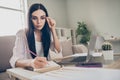 Photo of focused business woman hold pen sit sofa write notes fingers specs wear eyeglasses shirt in home workstation Royalty Free Stock Photo