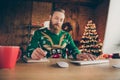 Photo of focused calm bearded man sit desk work pc write typing wear ugly deer sweater decorated office indoors