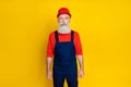 Photo of focused concentrated aged construction worker person isolated on yellow color background