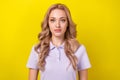 Photo of focused concentrated young girl calm face look camera isolated on vibrant yellow color background