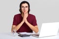 Photo of focused man with curly hair, keeps hands in praying gesture, believe in something good, wears hat and t shirt, works on