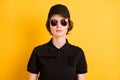 Photo of focused pretty young police woman wear round sunglass isolated on vivid yellow color background