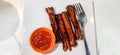 photo of four beef sausages with chili sauce and a fork