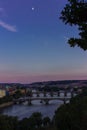 Photo of the four bridges of Prague at dusk, with the moon at the top of the photo. Blue and pink sky by the sunset Royalty Free Stock Photo