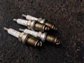 The four dirty spark plugs on the ground fulled with dirty engine oil Bangkok; Thailand April 2, 2018 Royalty Free Stock Photo