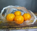 Photo of four oranges in a plastic shopping bag Royalty Free Stock Photo