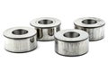 Photo of four turned bushings with a needle bearing dent, isolated on a white background.