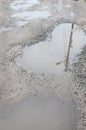 Photo of a fragment of a destroyed road with large puddles in rainy weather