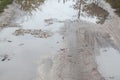 Photo of a fragment of a destroyed road with large puddles in rainy weather