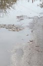 Photo of a fragment of a destroyed road with large puddles in rainy weather