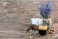 A photo of a fragrant black coffee in a glass mug next to chocolate cakes, hazelnuts, a white jug of milk Royalty Free Stock Photo