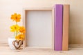 Photo frame with books and flowers on the wooden table Royalty Free Stock Photo
