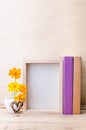 Photo frame with books and flowers on the wooden table Royalty Free Stock Photo