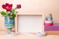 Photo frame with books and flowers on the wooden table Royalty Free Stock Photo