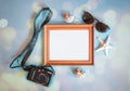 Photo frame, photo camera, sunglasses and seashells on blue background Royalty Free Stock Photo